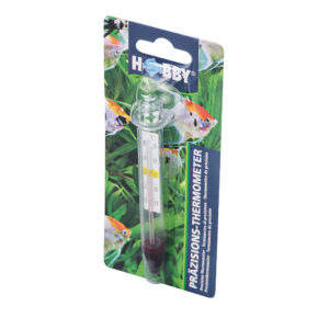 Un HOBBY Thermomètre de précision emballé avec une ventouse est présenté sur fond de poissons et de plantes aquatiques vertes, avec l'emballage étiqueté PRÄZISIONS-THERMOMETER et HOBBY.